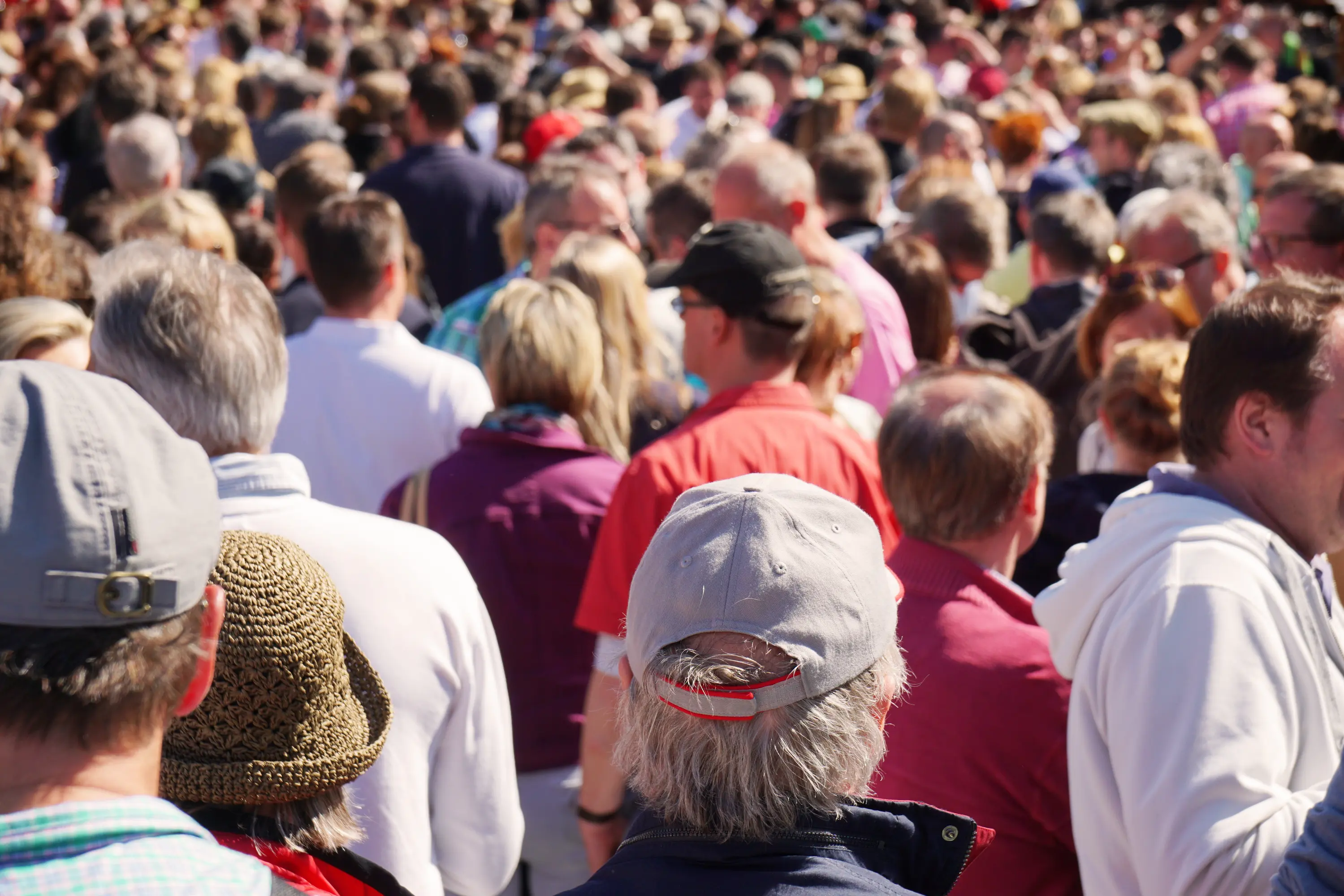 Group of people gathered together outdoors, smiling and engaging as part of a shared event experience.